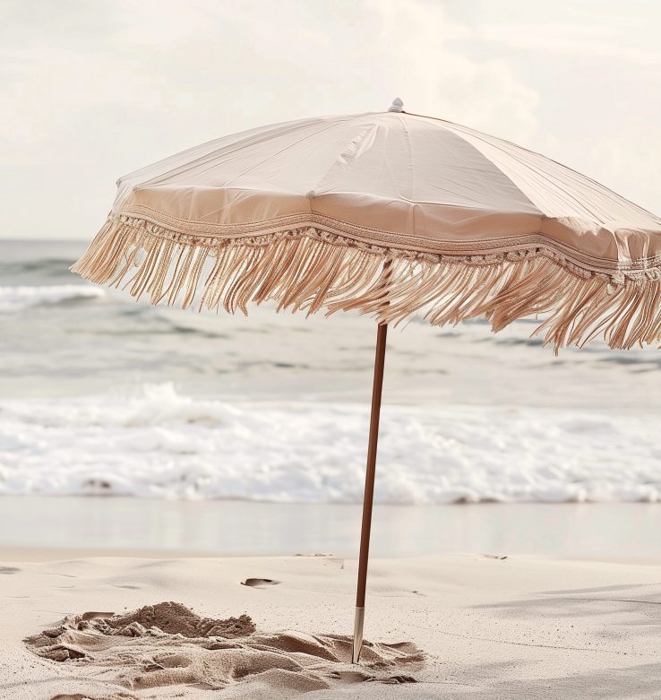 Retro fringe bone beach umbrella parasol on sand beach with windy sea waves cloud sky in earthy natural color vacation relaxation seaside coast resort ocean vibes eco summer holiday tropical campaign
